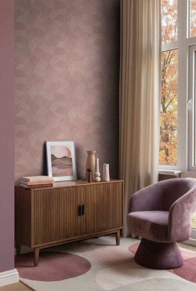 Tapete mit geometrischem Muster in Rosa und Mauve hinter einem Holzsideboard und einem lila Sessel in einem hellen, modernen Wohnzimmer.