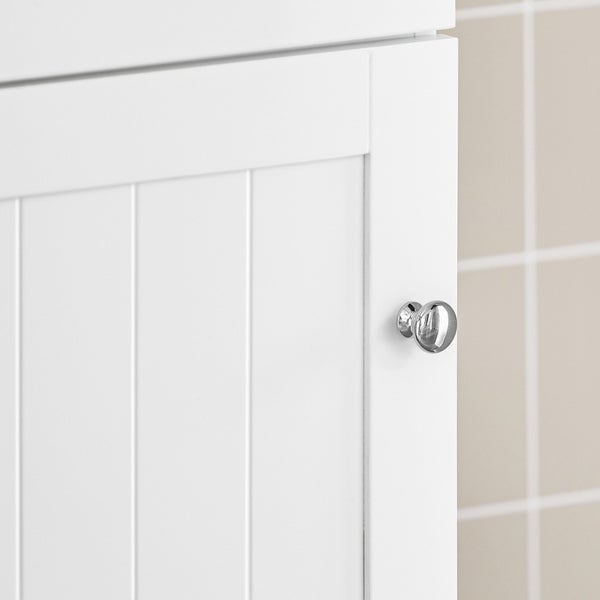 Detail eines weißen Badezimmerschranks mit verchromtem Knauf