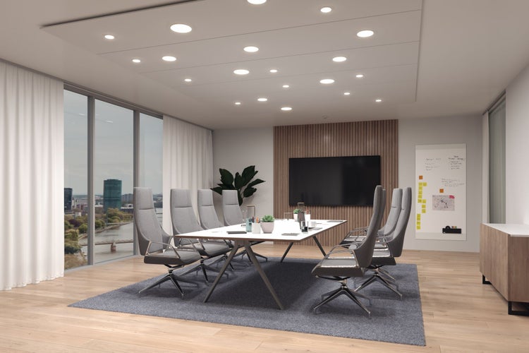 Moderner Konferenzraum mit großem weißen Tisch, grauen Bürostühlen, eingelassenen LED-Deckenleuchten und Stadtblick durch große Fenster.