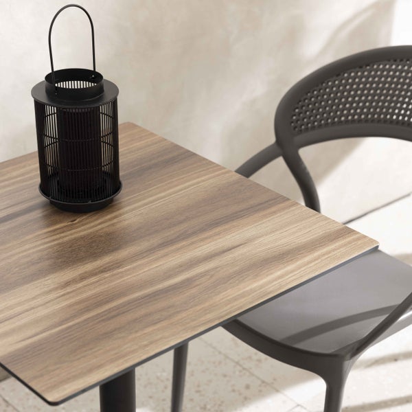 Bistro-Set bestehend aus einem quadratischen Tisch in Holzoptik und einem anthrazitfarbenen Kunststoffstuhl mit einer schwarzen Laterne aus Metall.