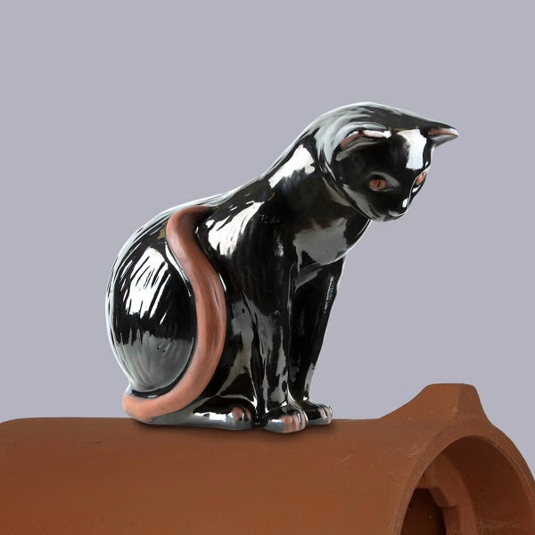 Firstfigur Katze aus glasiertem Ton für das Dach, sitzend auf einem Firstziegel.