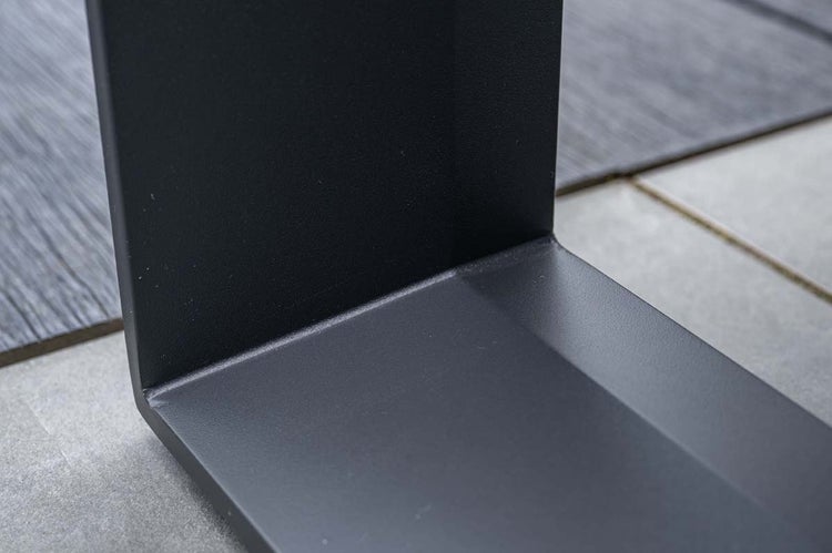 Detailaufnahme eines mattschwarzen Metallwinkels mit einer fein strukturierten Oberfläche.