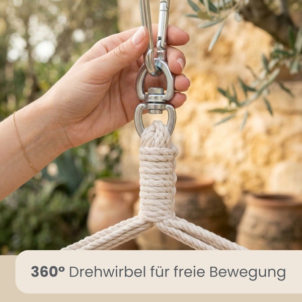 Hand hält 360 Grad Drehwirbel aus Metall mit Karabiner an geflochtenem Baumwollseil für einen Hängesessel im Außenbereich.