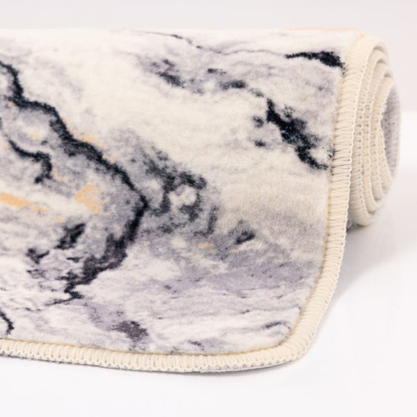 Aufgerollter Teppich mit Marmormuster und geketteltem Rand.