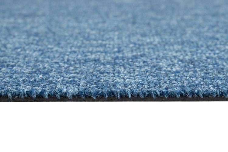 Nahaufnahme eines blauen Teppichbodens aus Nadelfilz mit strukturierter Oberfläche und dunklem Rücken.
