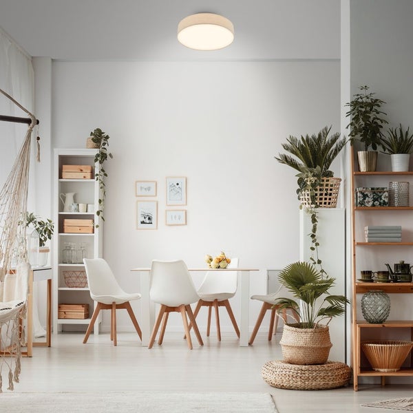 Moderne runde Deckenleuchte in einem hellen Esszimmer mit weißem Tisch, Stühlen und vielen Zimmerpflanzen in einem skandinavischen Wohnstil.