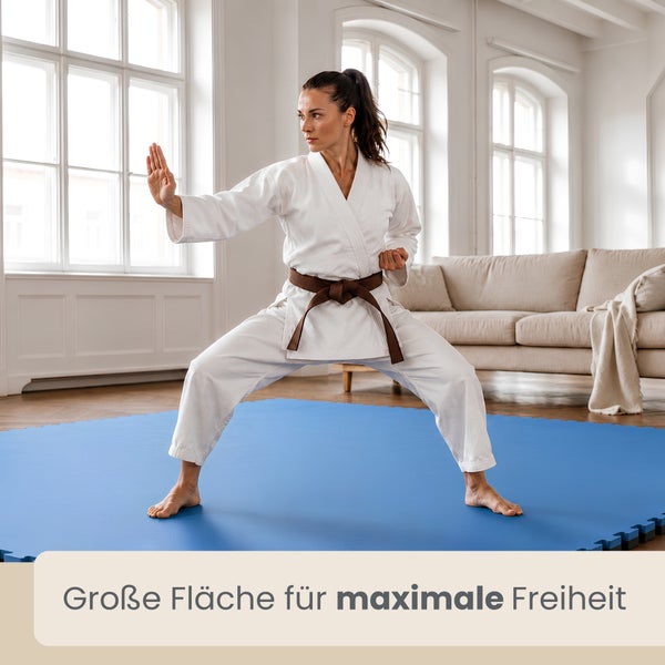 Frau im Karateanzug auf blauen Bodenschutzmatten in einem hellen Wohnzimmer. Große Fläche für maximale Freiheit.