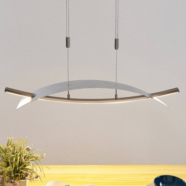 Moderne LED-Pendelleuchte in gebogenem Design aus Metall mit Betonoptik über einem Holztisch.