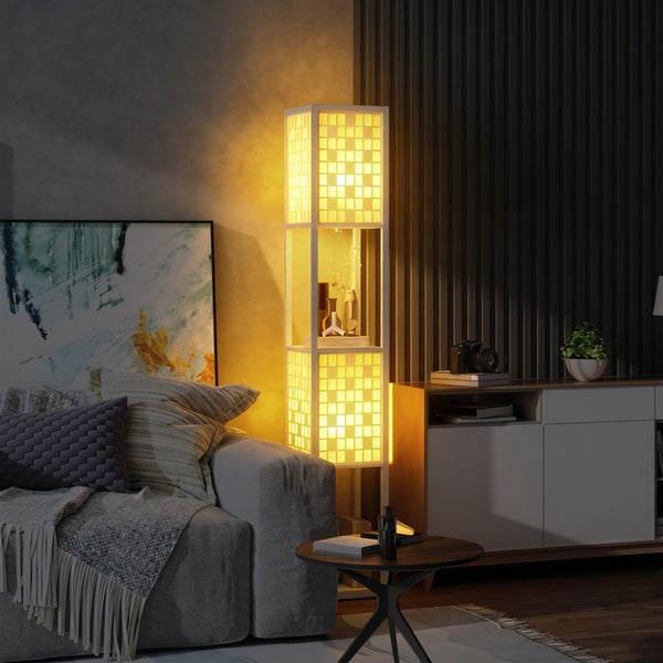 Moderne Stehleuchte mit integriertem Regal im Wohnzimmer. Beleuchtete Quadrate oben und unten verbreiten warmes Licht neben einem grauen Sofa.