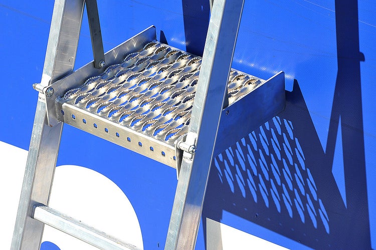 Detailaufnahme einer Aluminiumleiter mit geriffelter Stufe.