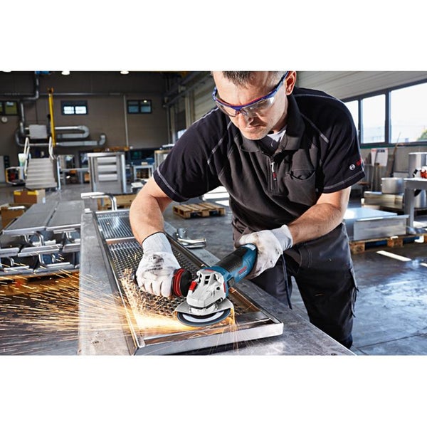 Ein Handwerker bearbeitet eine Metalloberfläche mit einem Bosch Professional Winkelschleifer in einer Werkstatt.