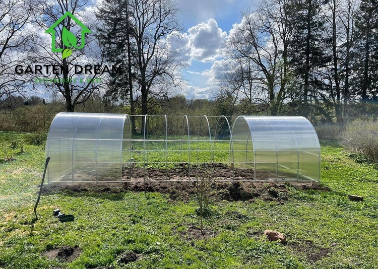 Tunnelgewächshaus im Garten mit Metallrahmen und transparenter Folie