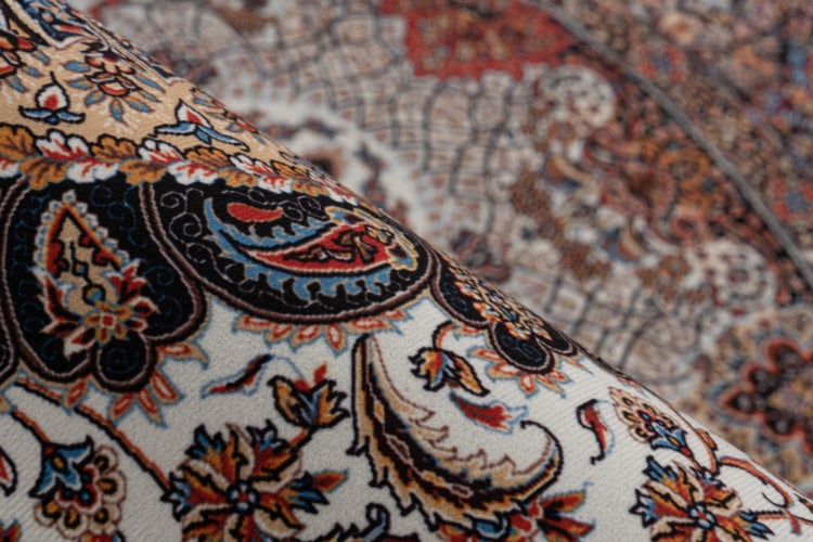Ein Orientteppich mit detailliertem floralem Muster und Paisleymotiven im orientalischen Stil.