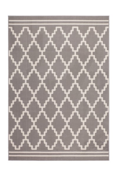 Wohnzimmer mit beigefarbenem Sofa, rotem Sessel, Topfpflanze, Galeriewand und einem großen Teppich mit geometrischem Muster auf dem Boden.