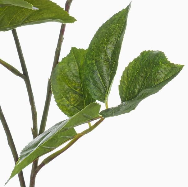 Nahaufnahme eines Kunstpflanzenzweigs mit grünen, gezackten Blättern.