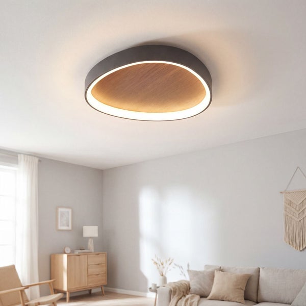 Moderne runde LED Deckenleuchte mit Holzoptik und dunkelgrauem Rahmen in einem hellen Wohnzimmer.