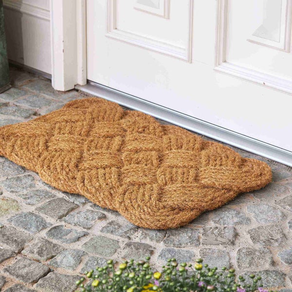 Fußmatte aus Kokosfasern vor einer Haustür