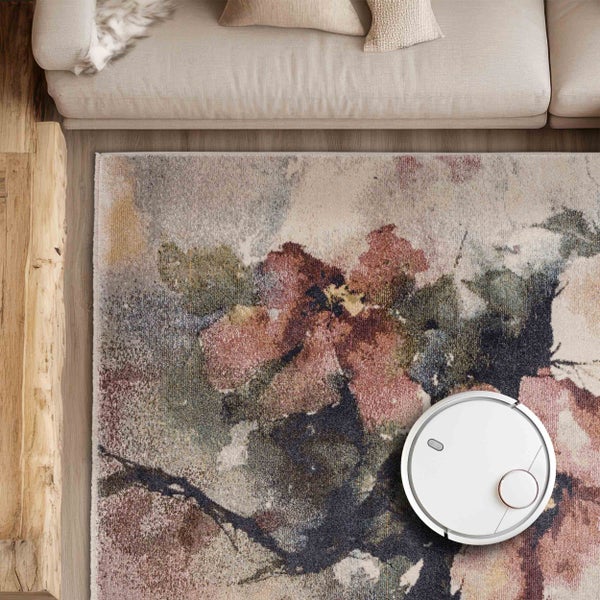 Saugroboter auf gemustertem Teppich in Wohnzimmerumgebung