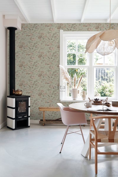 Gemütliches Esszimmer mit Ofen, Holztisch und floraler Tapete