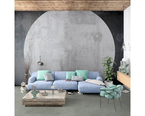 Heller Wohnraum mit Sofa, Tisch und Stuhl vor einer Betonwand