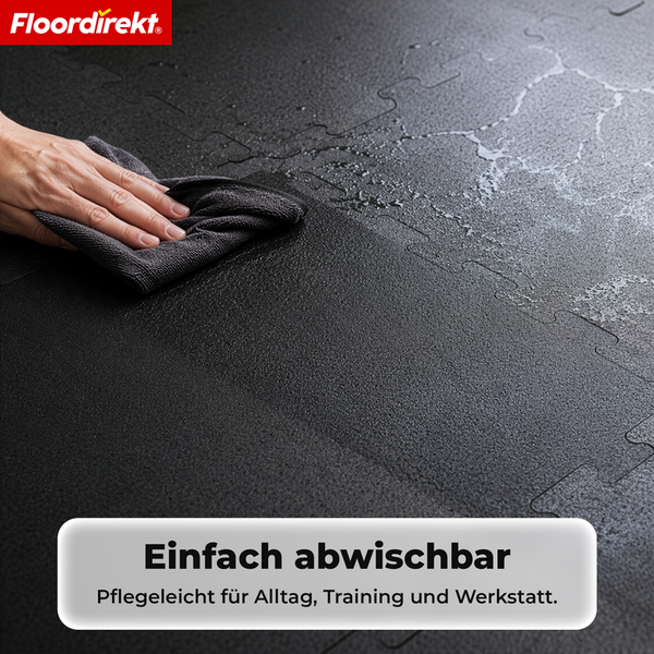 Eine Hand wischt Wasser von einer strukturierten Bodenschutzmatte ab. Floordirekt Logo. Pflegeleicht für Alltag, Training und Werkstatt.