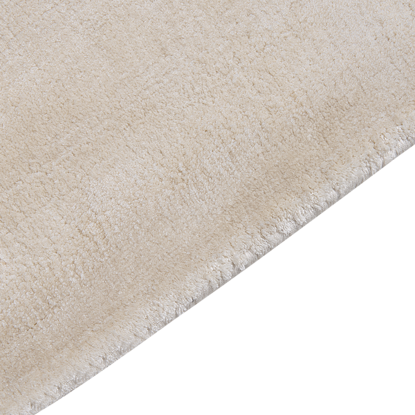 Beige Hochflor-Teppich in weicher Qualität mit geketteltem Rand.