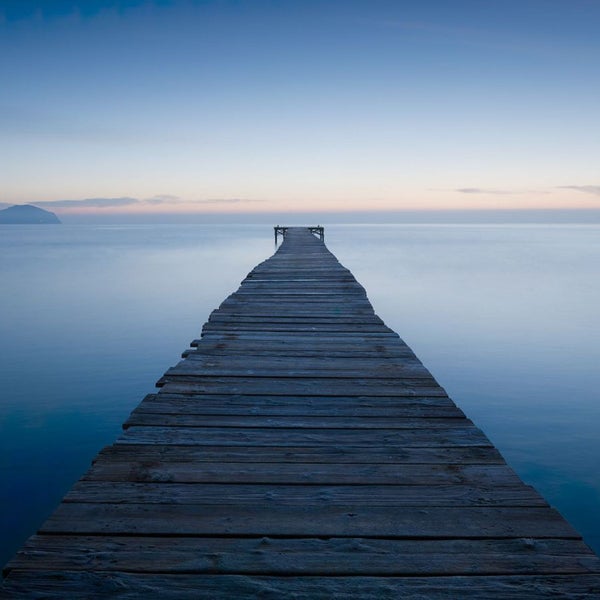 Holzsteg führt ins ruhige Wasser