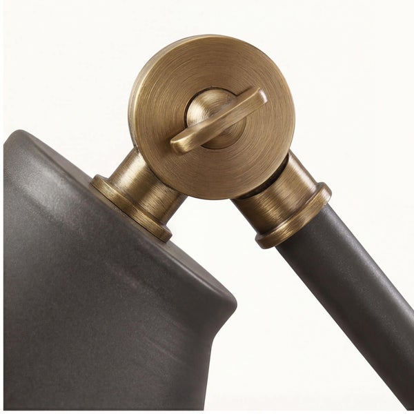 Nahaufnahme des verstellbaren Gelenks einer Lampe aus Messing, das den Lampenschirm mit der Halterung verbindet.