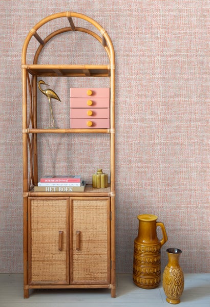 Einrichtungsszene mit Bambusregal, rosa Schubladen, Dekoration und Vasen.