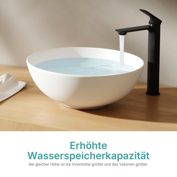Weißes Aufsatzwaschbecken in Schalenform auf einer Holzoberfläche mit einer mattschwarzen Waschtischarmatur und fließendem Wasser.