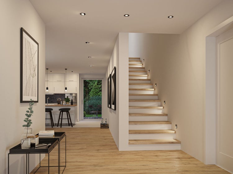 Moderner heller Innenraum mit Holzfußboden, einer Holztreppe mit Wandbeleuchtung, Einbaustrahlern und einer Küche im Hintergrund.