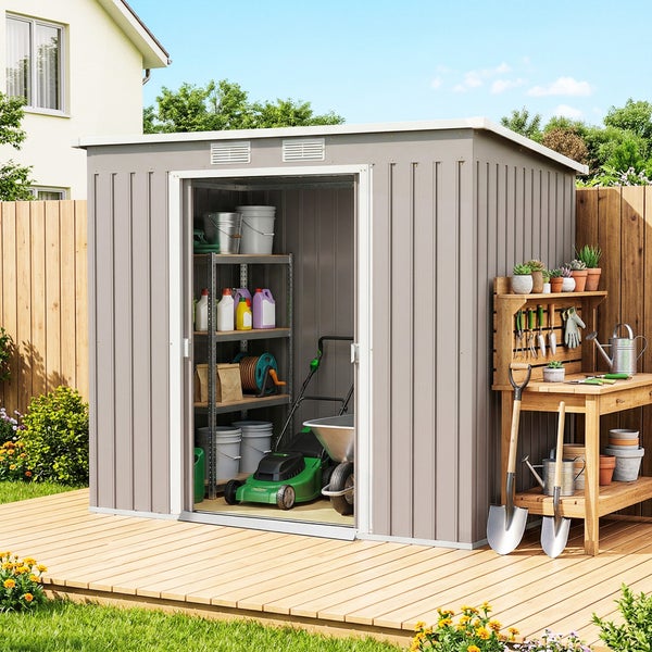 Graues Metall-Gerätehaus auf Holzterrasse mit Regalen, Rasenmäher und Gartenwerkzeug. Offene Tür zeigt Stauraum, daneben steht ein Pflanztisch.