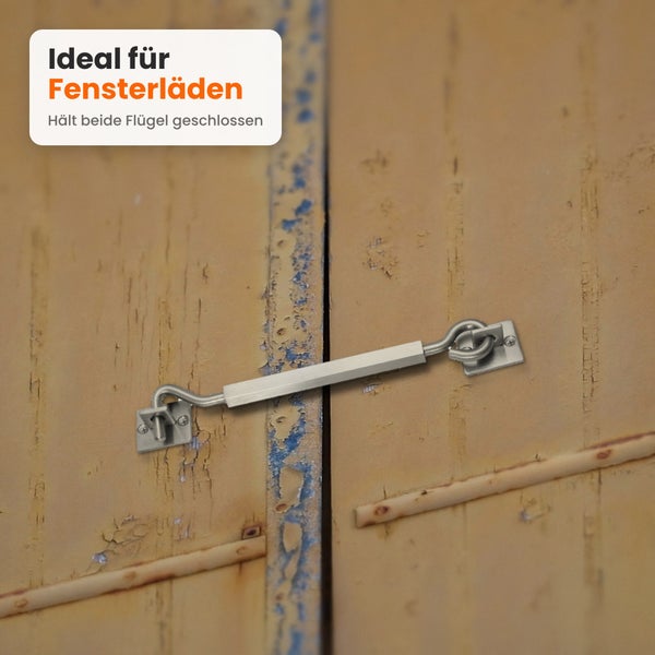 Ein metallischer Fensterladenriegel montiert an zwei Holzfensterflügeln zum sicheren Verschließen.