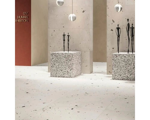 Großformatige Boden- und Wandfliesen in Terrazzo-Optik in einem minimalistisch gestalteten Ausstellungsraum mit Skulpturen.