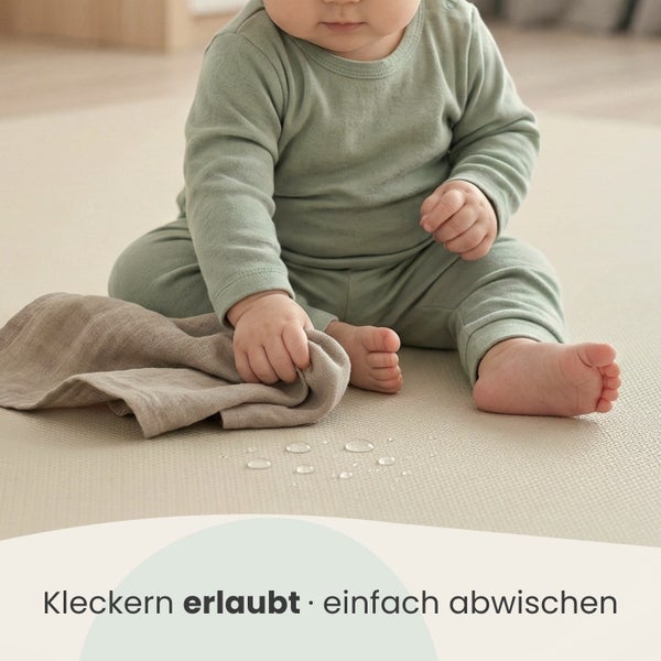 Kind sitzt auf wasserabweisender Spielmatte, Wassertropfen auf der Oberfläche werden mit einem Tuch abgewischt.