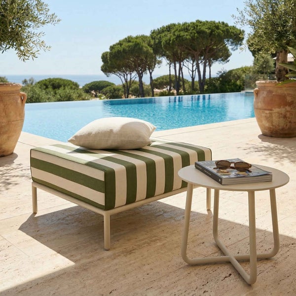 Moderne Terrasse mit grün-weiß gestreiftem Hocker, einem cremefarbenen runden Beistelltisch und einem Pool im hellen Außenbereich.