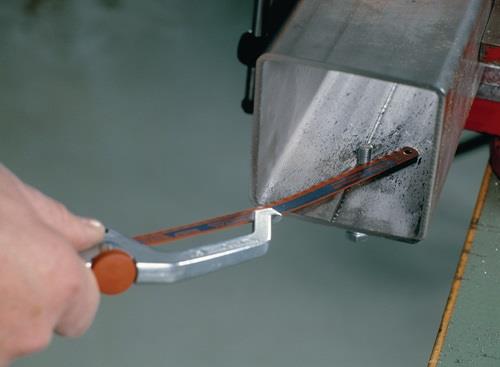 Eine Metallsäge schneidet ein Metallrohr.