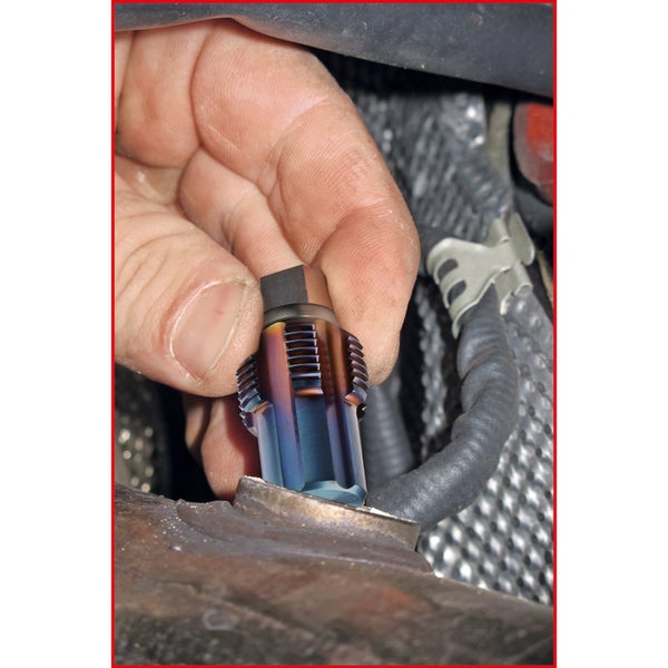 Eine Hand führt einen Gewindebohrer in ein Werkstück ein.