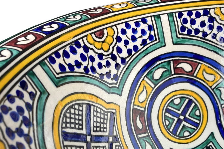 Detailaufnahme eines handbemalten Keramiktellers mit floralen und geometrischen Mustern