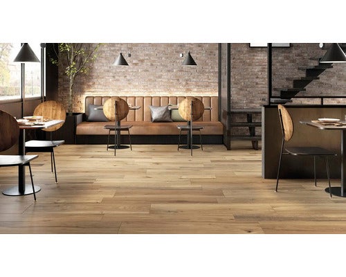 Innenraum mit Bodenfliesen in Holzoptik, Tischen und Sitzgelegenheiten in einem Restaurant.