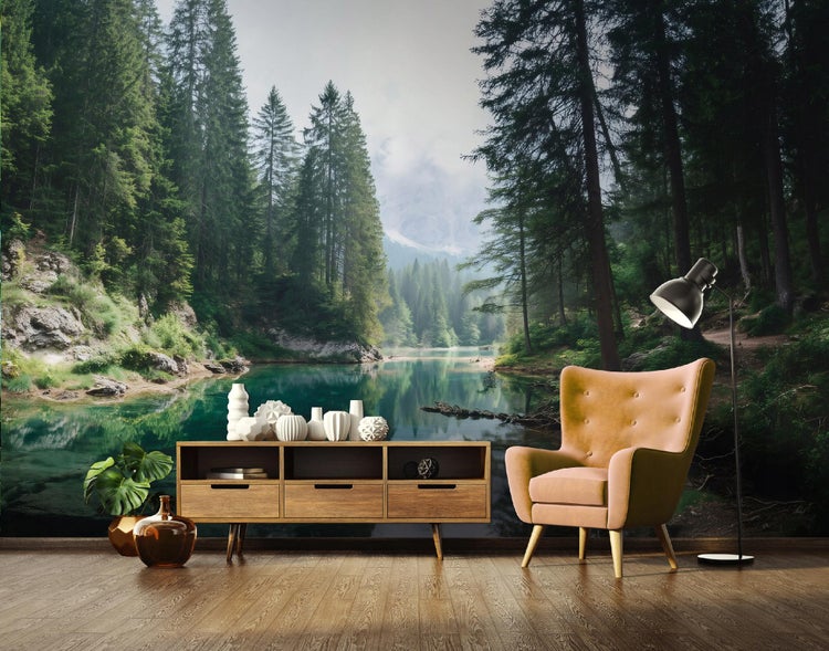Wohnzimmer mit Fototapete eines Bergsees mit Nadelwald, Sessel, Sideboard und Stehlampe