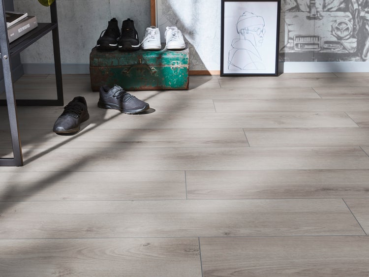 Moderner Wohnraum mit hellem Laminatboden in Holzoptik mit natürlicher Maserung in einem Flur mit Schuhen und dekorativen Elementen.