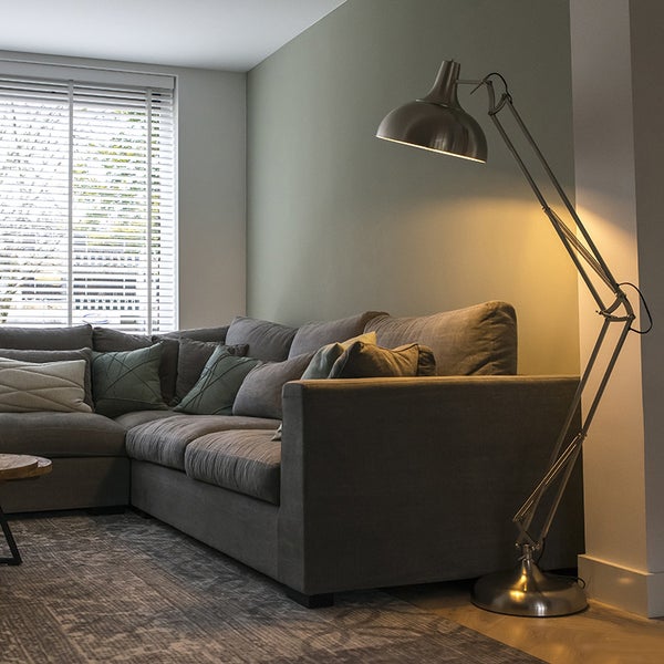 Wohnzimmer mit Ecksofa und Stehlampe