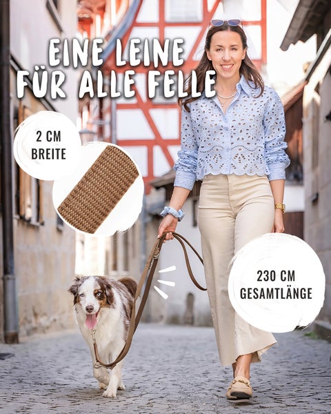Frau führt Hund an brauner, gewebter Hundeleine in gepflasterter Gasse. Maße: 2 Zentimeter Breite und 230 Zentimeter Gesamtlänge.