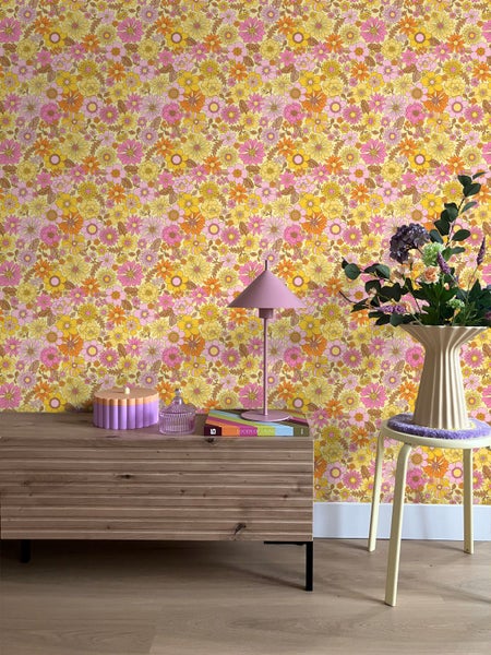 Szene mit Blumentapete, Kommode, Tischlampe, Dekoration und Hocker