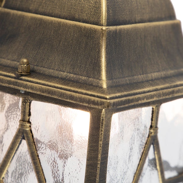 Nahaufnahme einer Außenwandleuchte im klassischen Laternenstil aus Metall in Altmessing-Optik mit strukturiertem Glas.