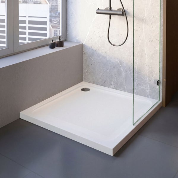 Quadratische weiße Duschwanne in einem modernen Badezimmer mit Glaswand, Armatur und Wandfliesen in Marmoroptik.