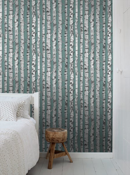 Schlafzimmer mit Birkenmuster-Tapete, Bett und Hocker