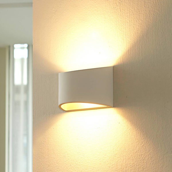 Moderne Wandleuchte mit Up-Down-Lichteffekt an einer Wand, warmweißes Licht.