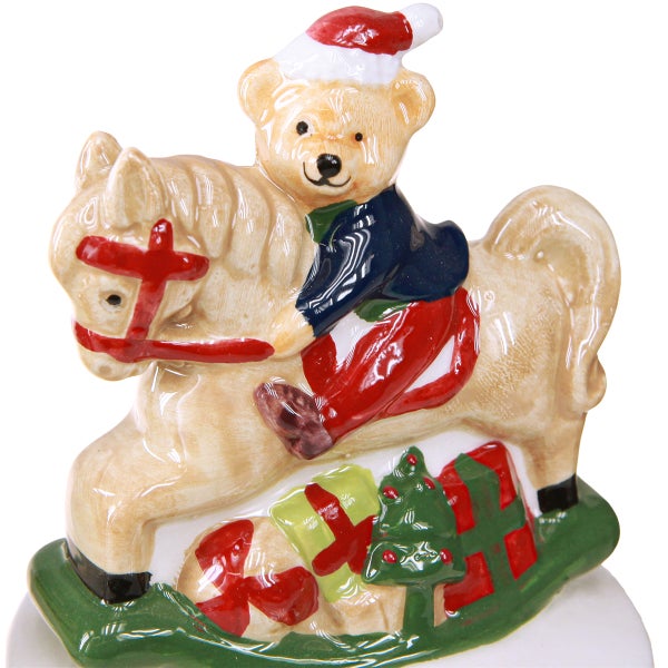 Keramikfigur mit Teddybär auf Schaukelpferd und Weihnachtsgeschenken